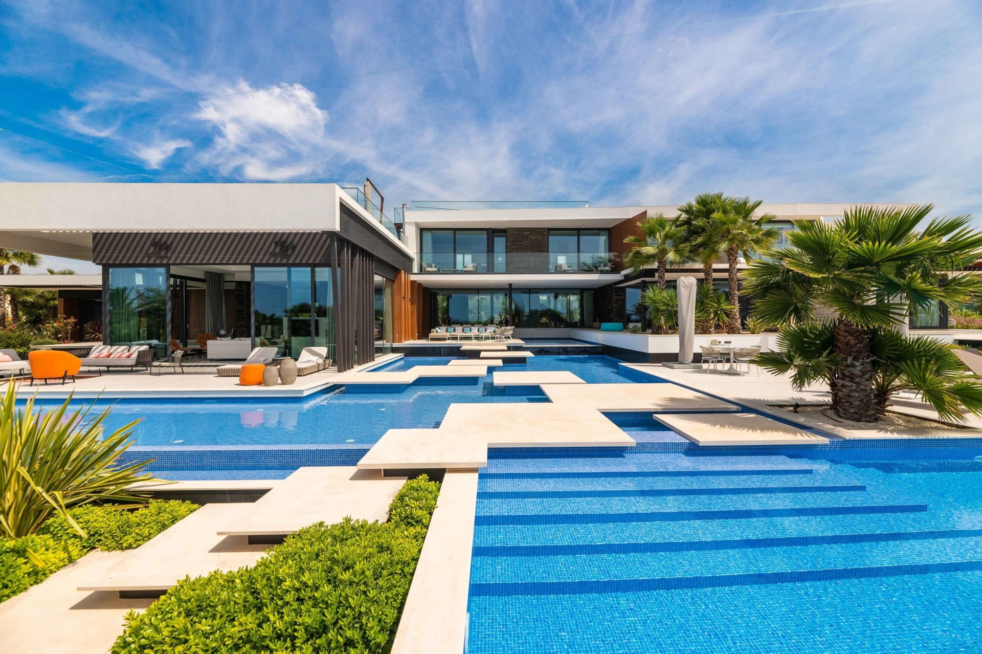 Cascading Pool Terraces with Stone Walkways Leading to the Modern Villa