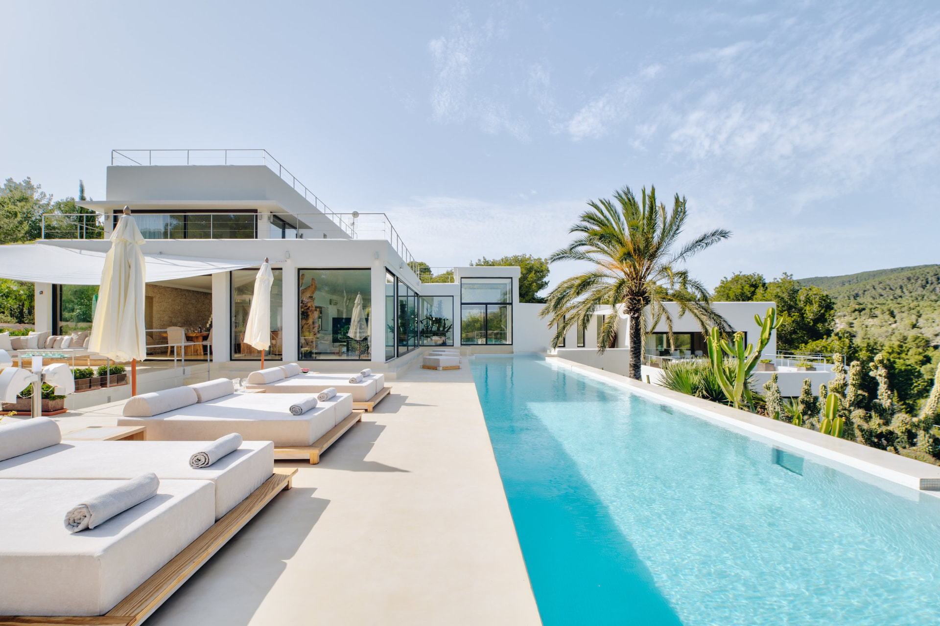 Infinity Pool and Sun Loungers Beside the White Modern Villa