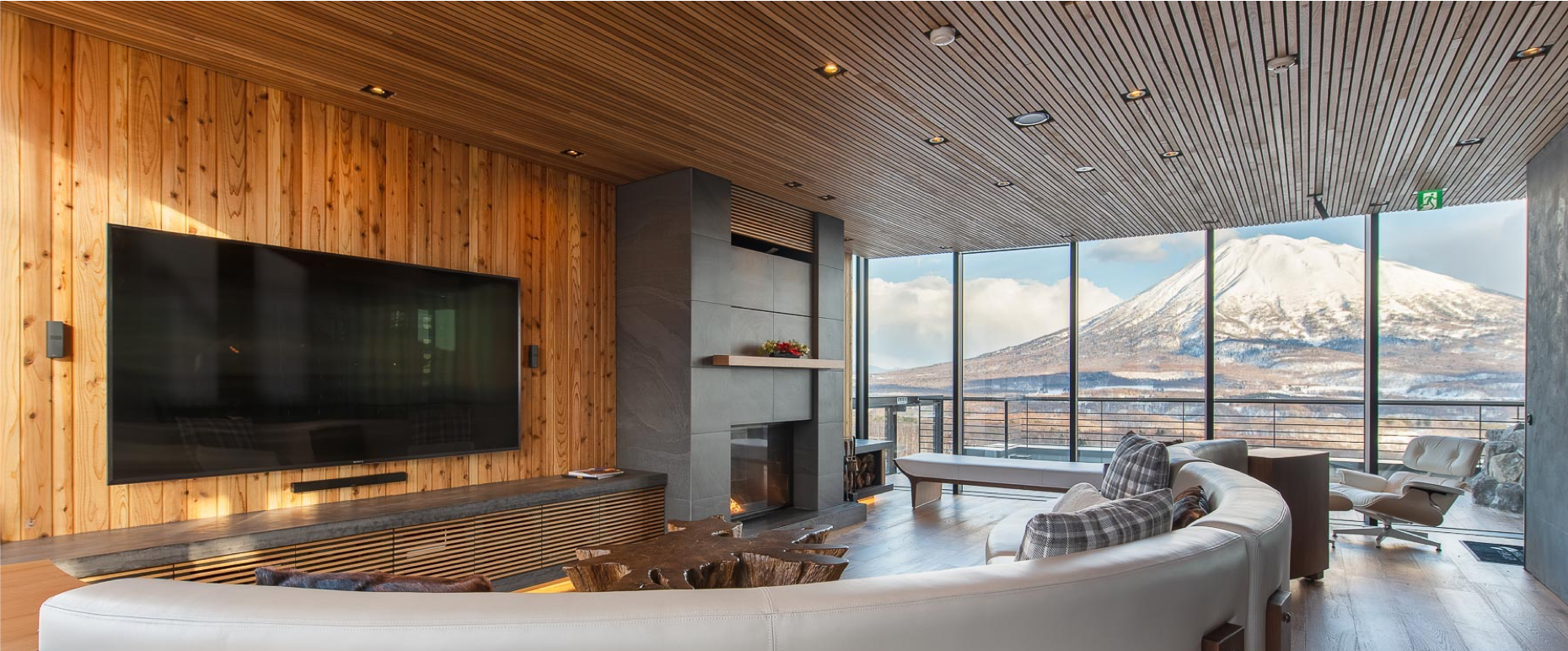 Living Room with Cedar Ceiling, Stone Fireplace and Mt. Yotei Views