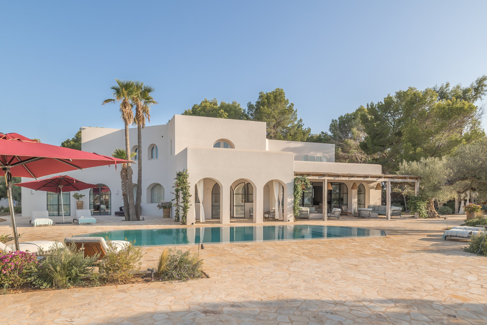 Whitewashed Villa Facade with Arched Terrace and Poolside Sun Deck