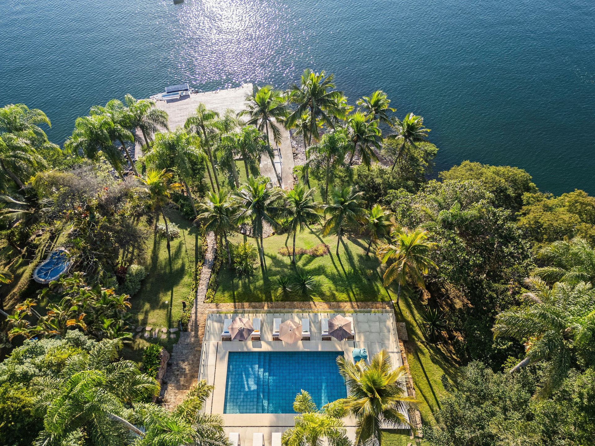 Aerial View of the Pool, Sun Terrace and Grounds Extending to a Private Pier over the Bay