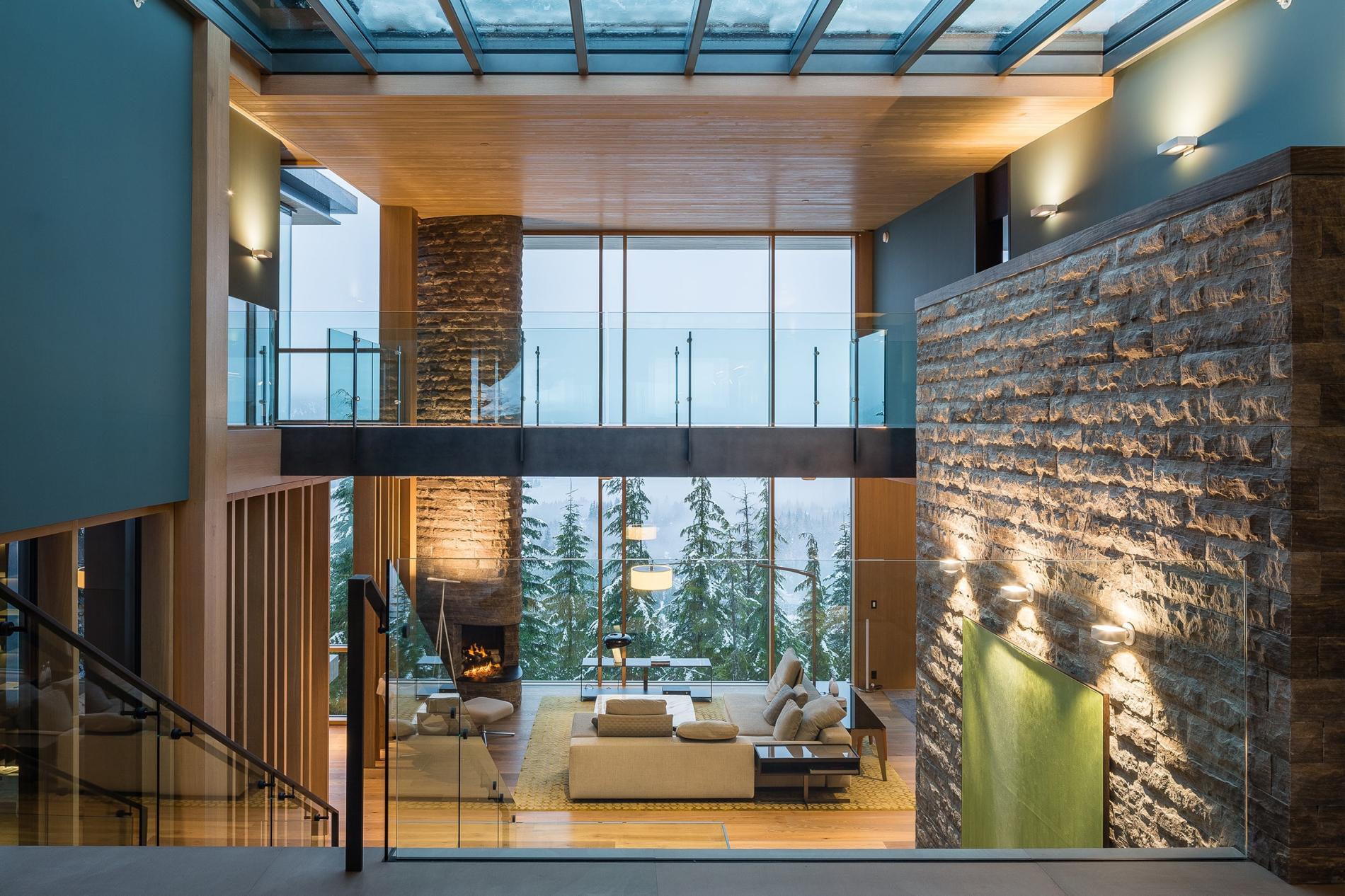 Double-Height Great Room with Stone Chimney, Skylights and Forest Views